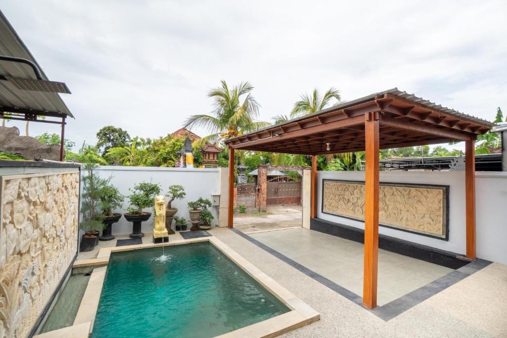 une piscine dans le jardin d'une maison avec un pavillon dans l'établissement Villa Aditya, à Babakan Sangsit