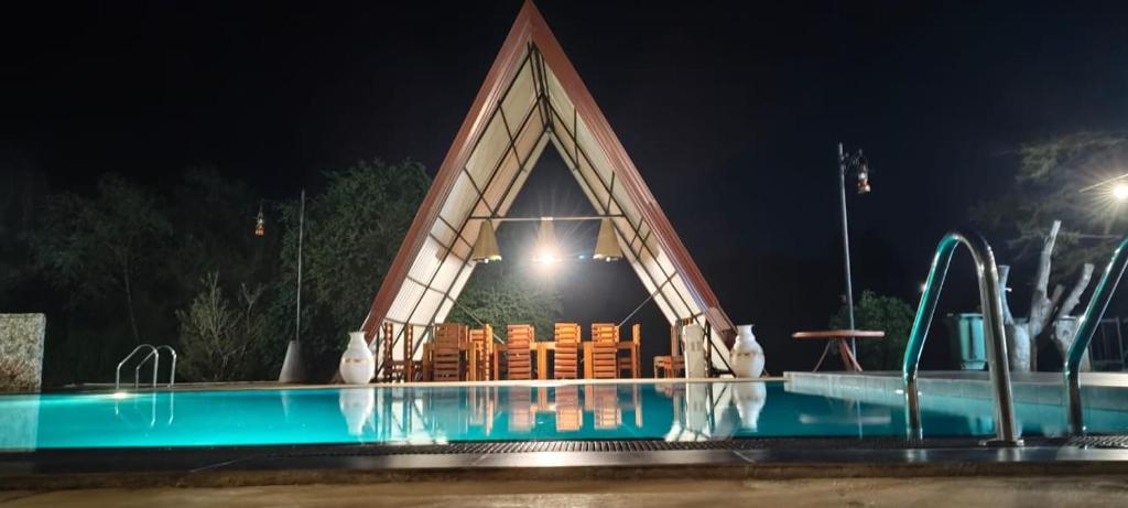 ein Schwimmbad vor einem Gebäude bei Nacht in der Unterkunft OrientalResort Kekirawa in Kekirawa