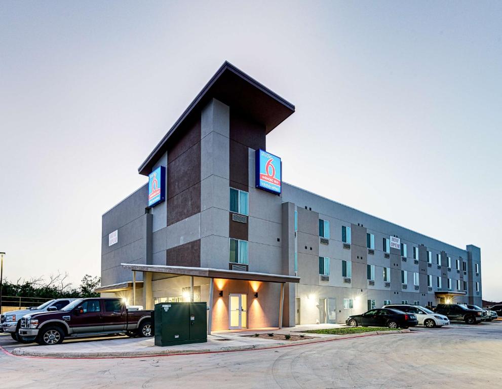 a large building with a truck parked in a parking lot at Studio 6-Sweetwater, TX in Sweetwater