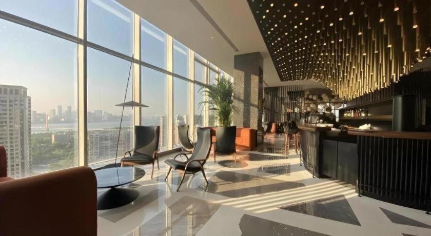 a hotel lobby with chairs and tables and windows at Twinkle hotel Hangzhou in Hangzhou