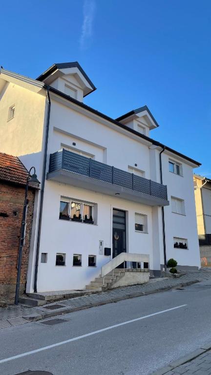 un edificio blanco con ventanas negras en una calle en Vanjkuš, en Marija Bistrica