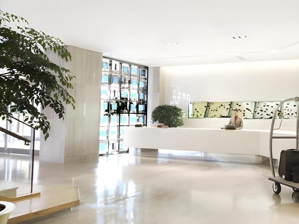 ein Wohnzimmer mit einem weißen Sofa und einigen Pflanzen in der Unterkunft Dusit D2 Binhu Changzhou Hotel in Changzhou