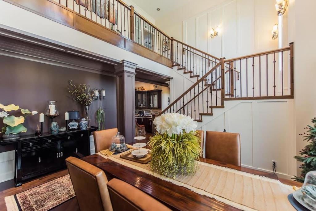 a dining room with a table and a staircase at Grace Guest House in White Rock