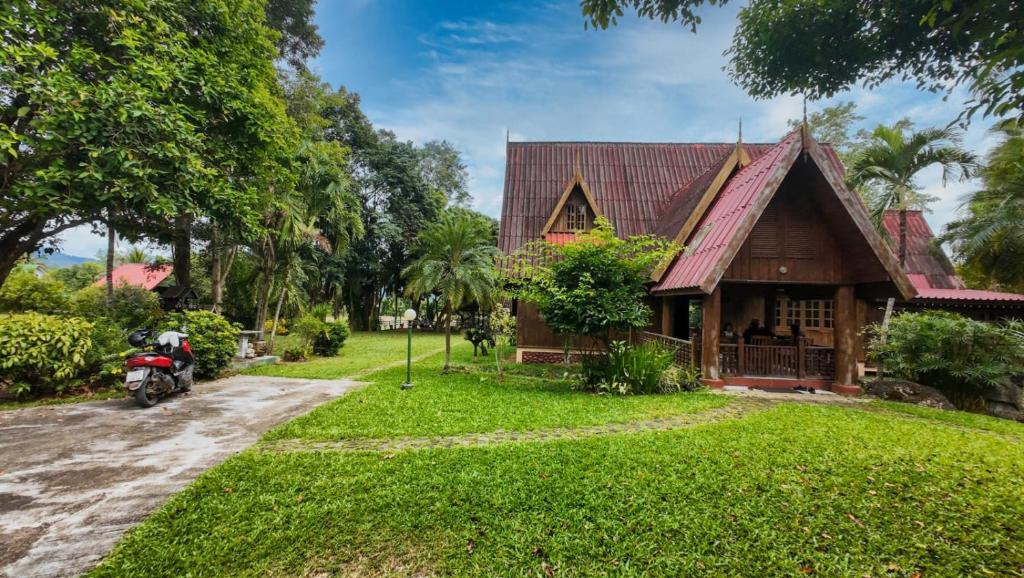 a house with a motorcycle parked in front of it at Babazia Community in Pai