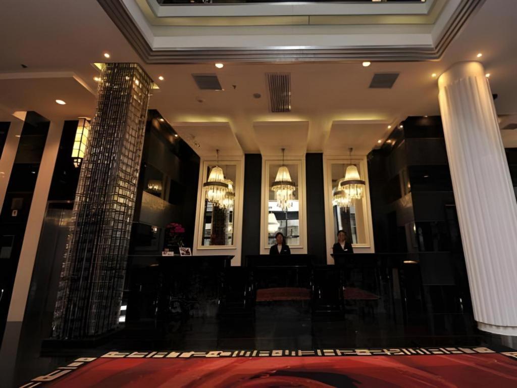 eine Lobby eines Hotels mit Menschen, die in einem Zimmer sitzen in der Unterkunft Elegance Bund Hotel in Shanghai