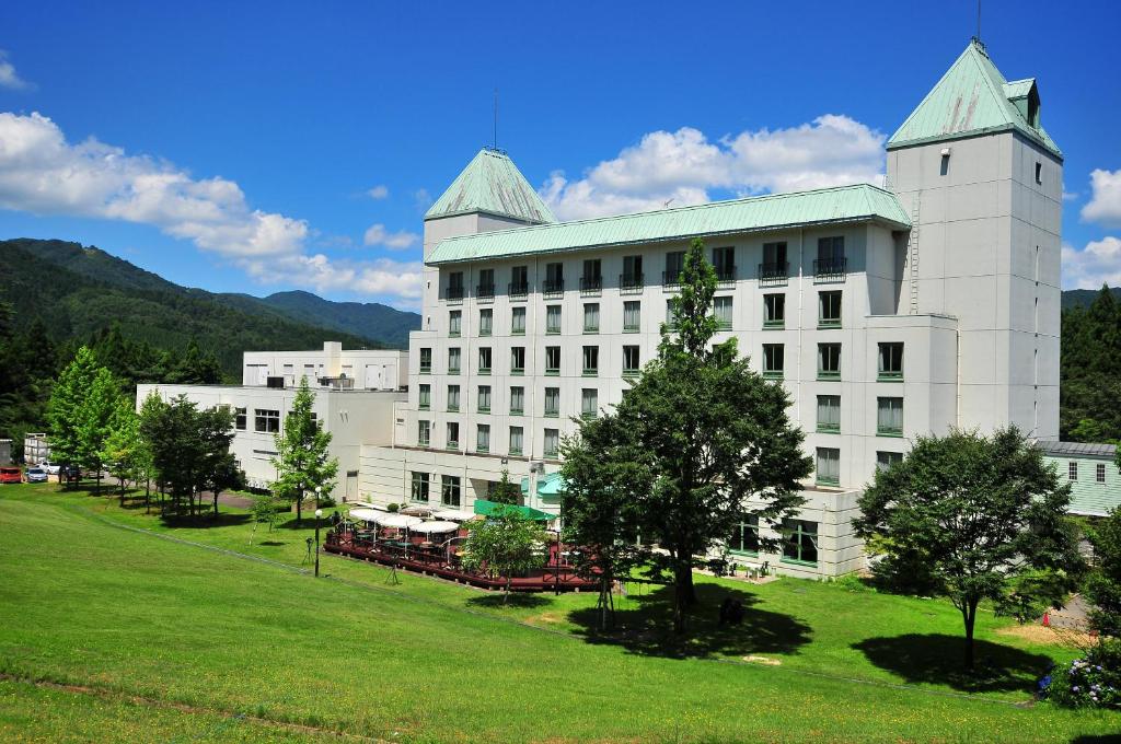 un gran edificio blanco con una torre encima en Blue Ridge Hotel en Toyooka