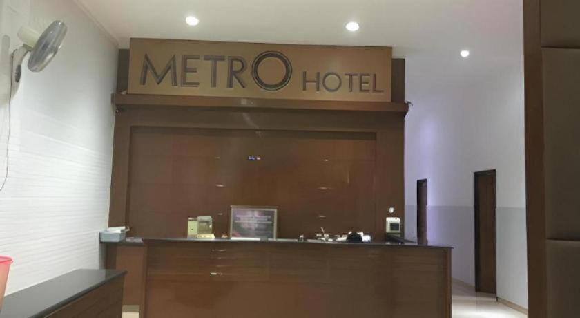 a meo hotel sign on the wall of a store at Metro Hotel in Surabaya