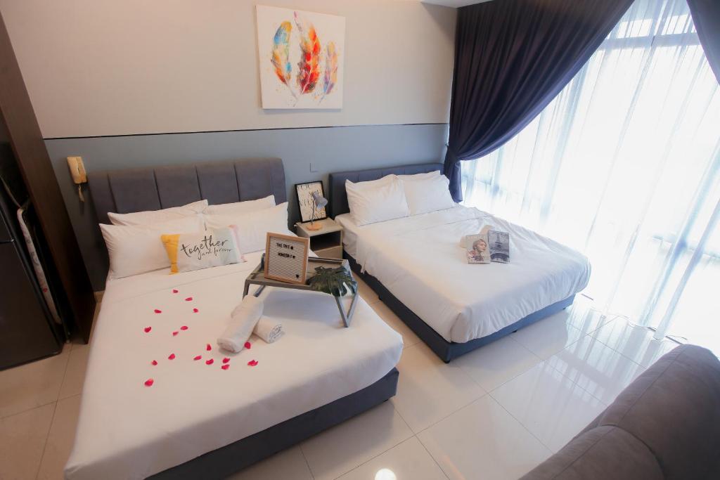 ein Hotelzimmer mit 2 Betten mit Herz darauf in der Unterkunft Grand Medini Residence By The one - Cozy Studio 5pax in Nusajaya