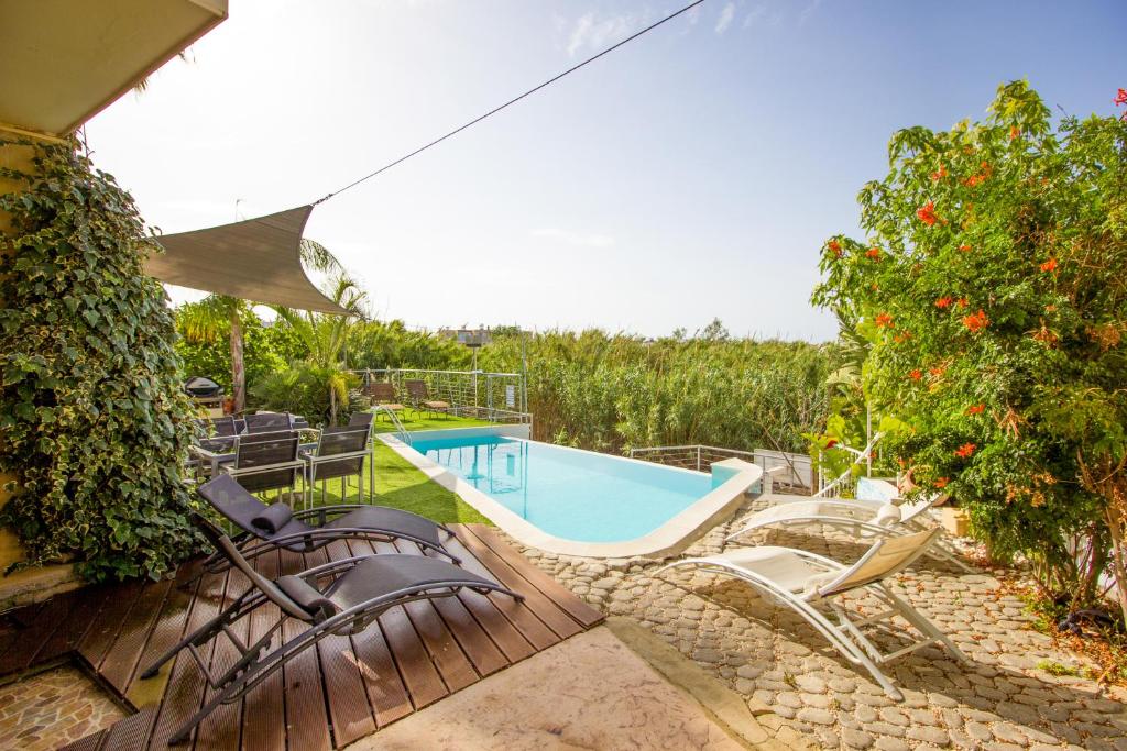 un patio con sillas y una piscina en Gold Sand Villa, en Protaras
