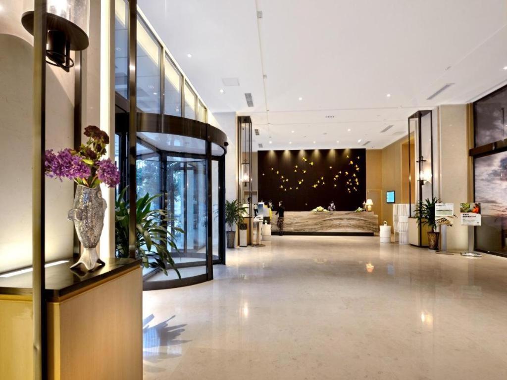 eine Hotellobby mit einem Bett und einer Blumenvase in der Unterkunft Atour Hotel Chengdu High-Tech Zone in Chengdu