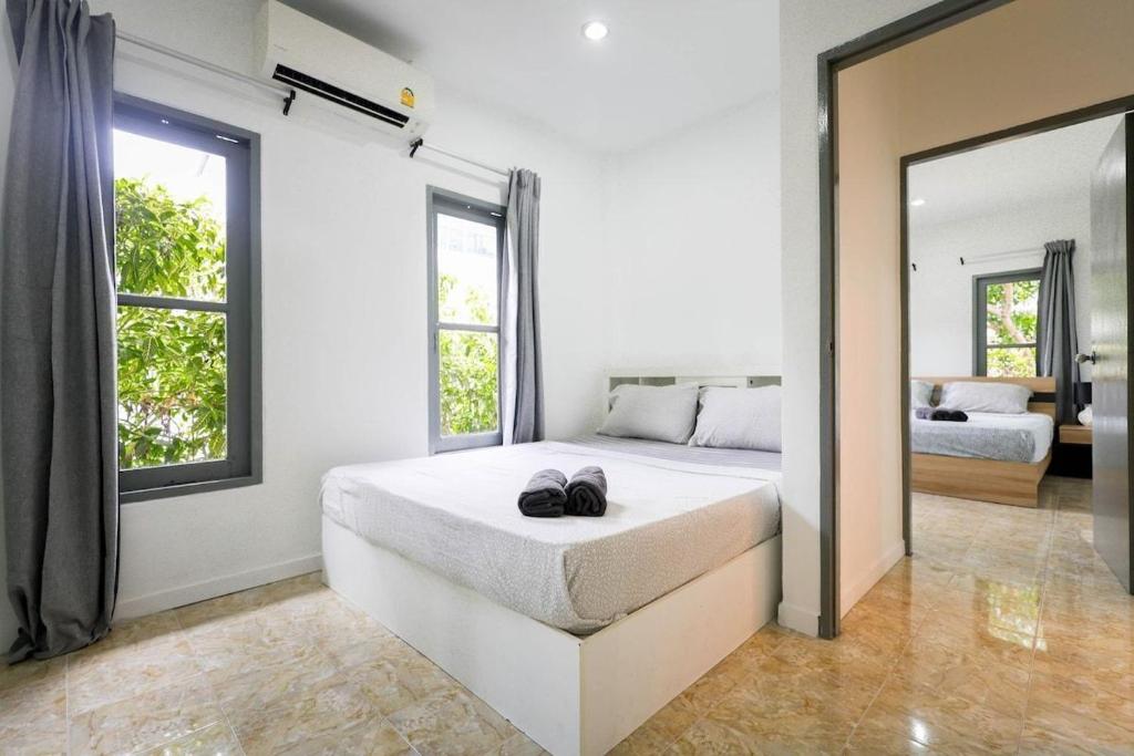 Sisters Ari 2-bedrooms house, Bang Tao beach في Ban Thalat Choeng Thale: غرفة نوم بها سرير كبير ومرآة