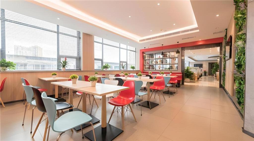 ein Restaurant mit Tischen und Stühlen in einem Gebäude in der Unterkunft ibis Chengdu East Railway Station Hotel in Chengdu