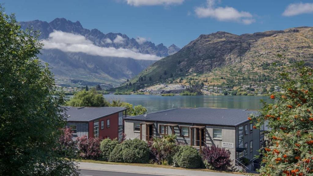a house with a view of a lake and mountains at Marina Quarters 406B in Queenstown