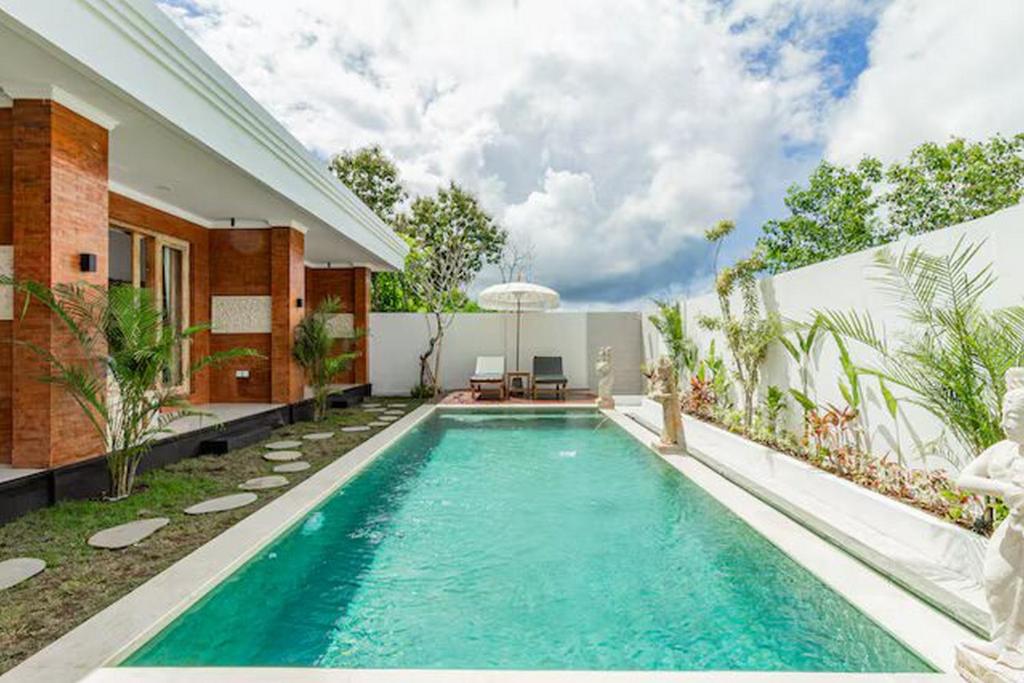 ein Swimmingpool im Hinterhof eines Hauses in der Unterkunft The Lavana Hi Inn GWK in Uluwatu