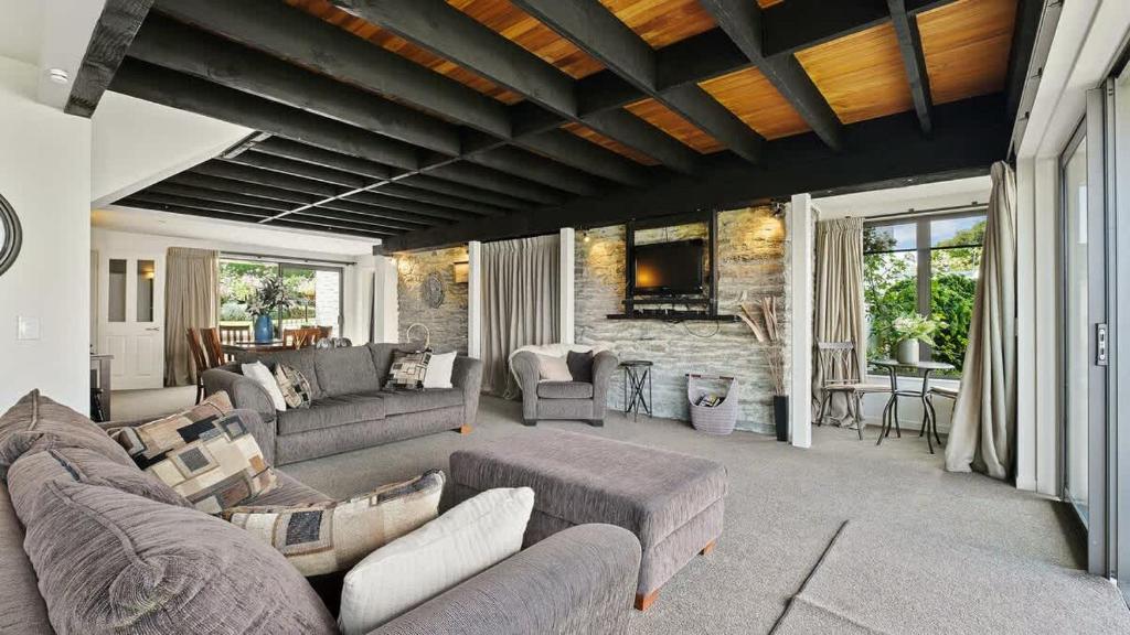 a living room with couches and a stone wall at Couple’s Retreat in Queenstown