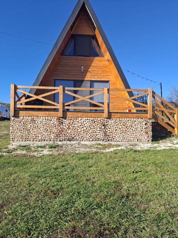 a cabin with a thatched roof on a field at Cabana Teo&Matei in Mihăeşti