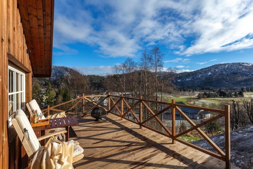 a wooden deck with a view of the mountains at Great mountain cabin in Sirdal with hot tub and views! in Dirdal