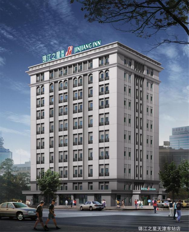 a white building with a sign on top of it at Jinjiang Inn - Tianjin Train Station in Tianjin