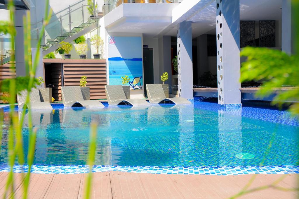 a swimming pool with lounge chairs in a resort at Eloisa Royal Suites in Mactan