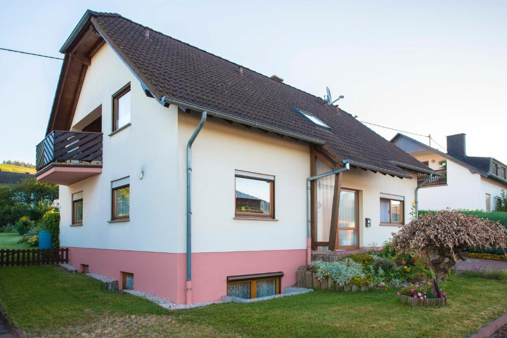 Casa blanca y rosa con techo negro en Haus Elfriede, en Niedermennig