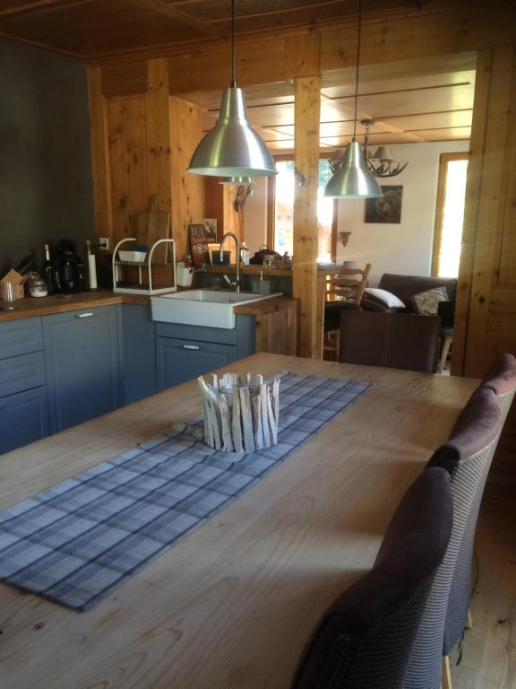 uma cozinha e sala de jantar com uma mesa de madeira em La Providence em Morgins