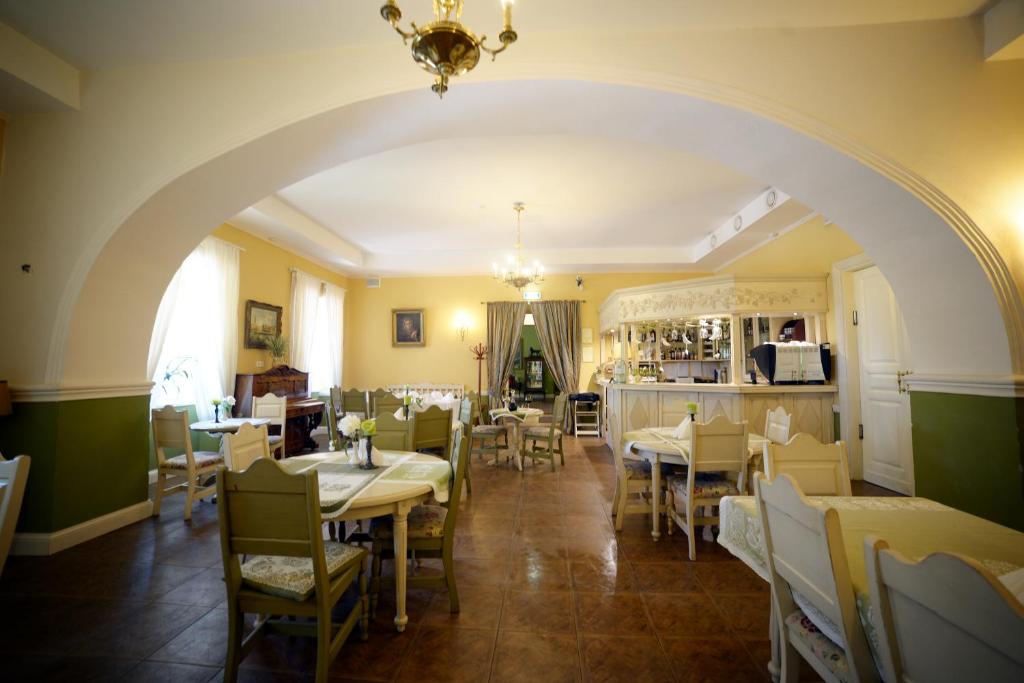 an archway in a restaurant with tables and chairs at Bistrampolis Manor in Kučiai