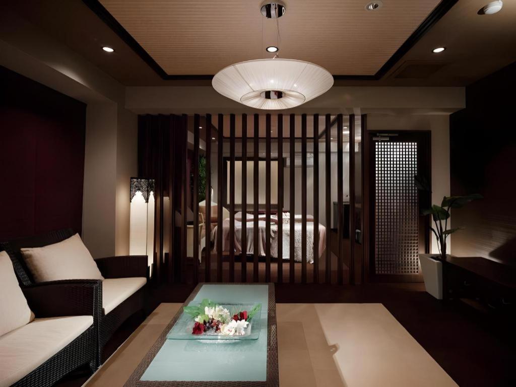 a living room with a couch and a table at Sakuraan Kawaguchiko Hotel in Fujikawaguchiko