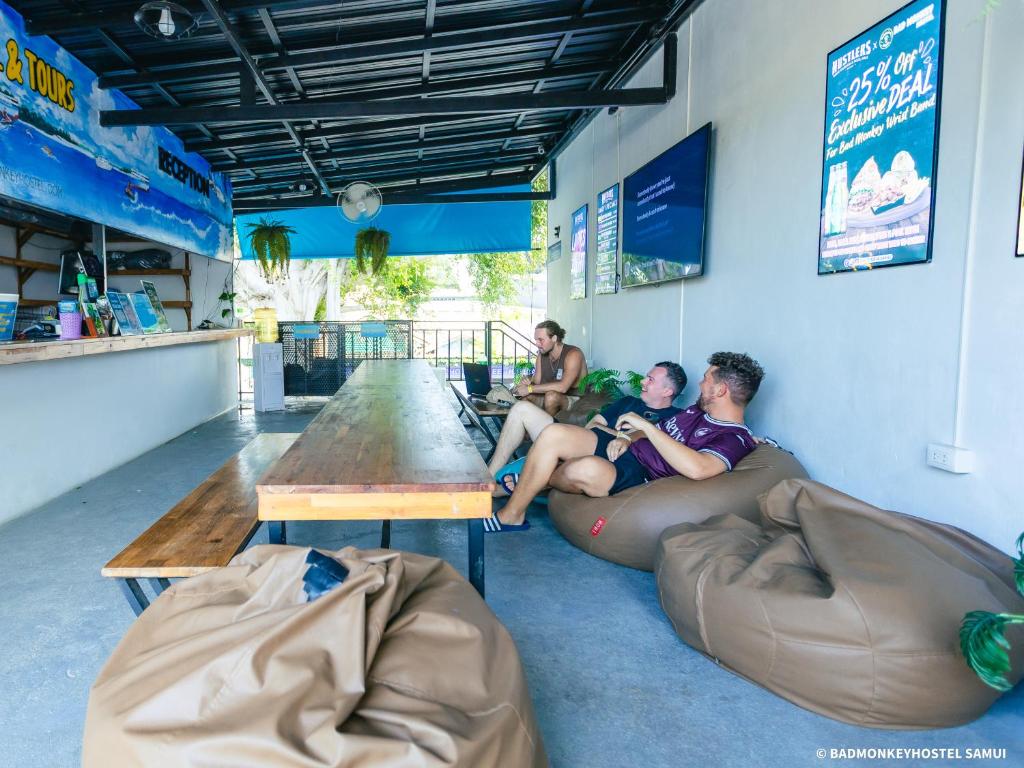 a group of people sitting on a couch in a bar at Bad Monkey Samui Hostel in Chaweng