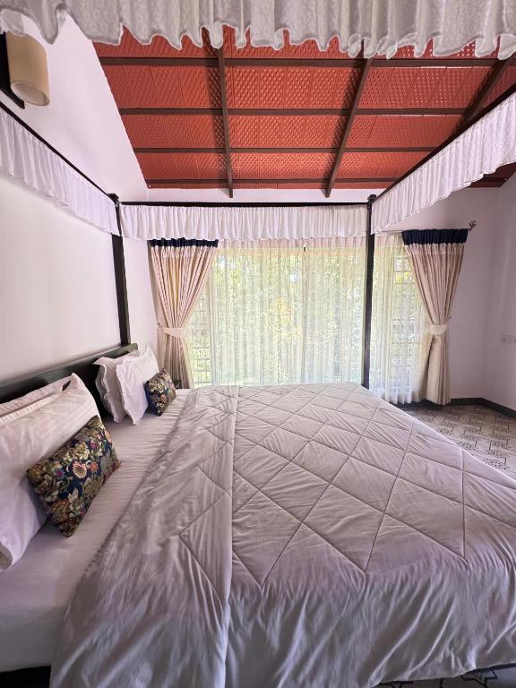 ein großes Bett in einem Schlafzimmer mit großem Fenster in der Unterkunft The Coffee Retreat in Mudigere