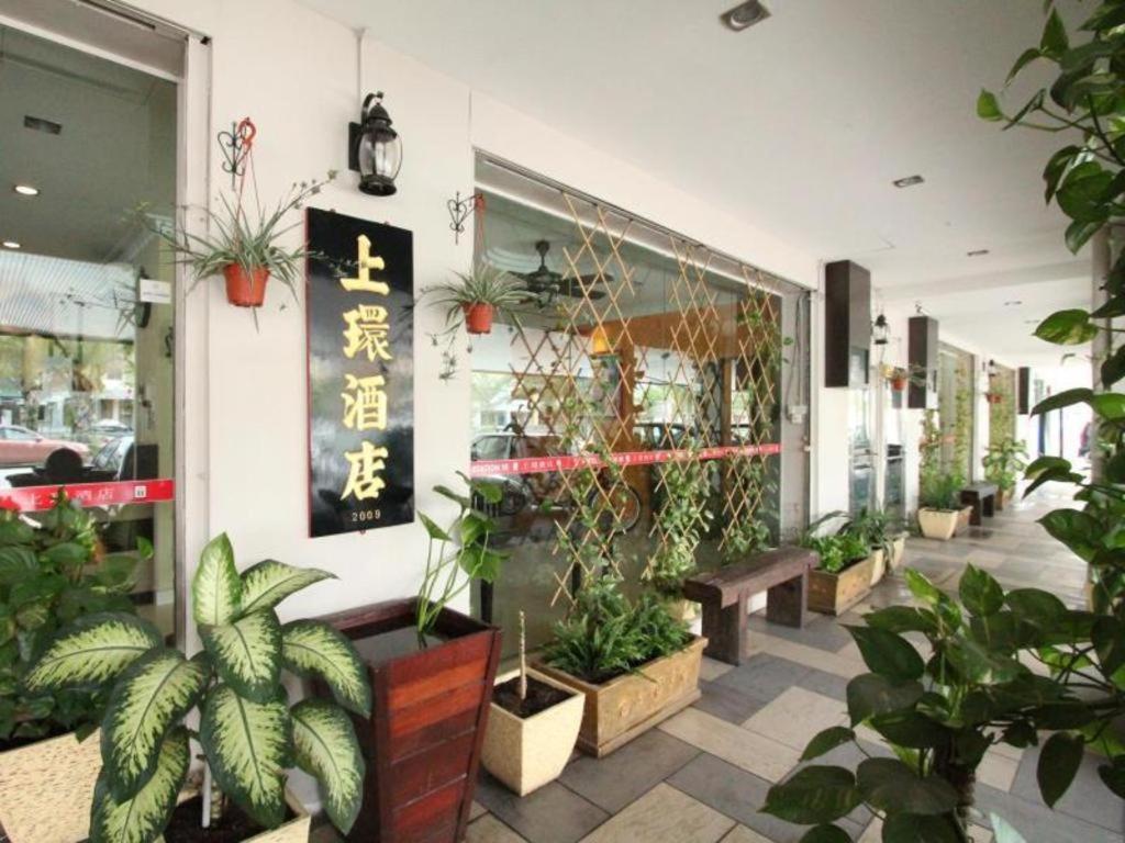 a store front with plants and a bench in front at Hotel Station 18 in Kampong Kuala Punti