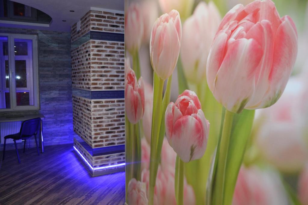 un montón de tulipanes rosas en un jarrón en una habitación en Apartment on Yuvilejnyj avenue en Járkov