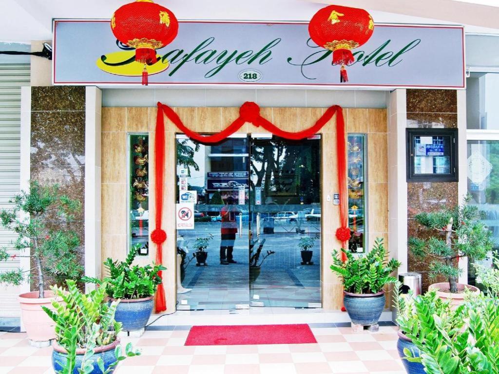 a store front with a red doorway with a sign at Rafayeh Hotel in Kampong Lobok