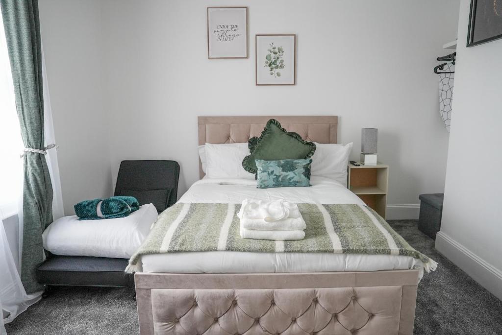 a bedroom with a large bed and a chair at The Luma Suite in Albrighton