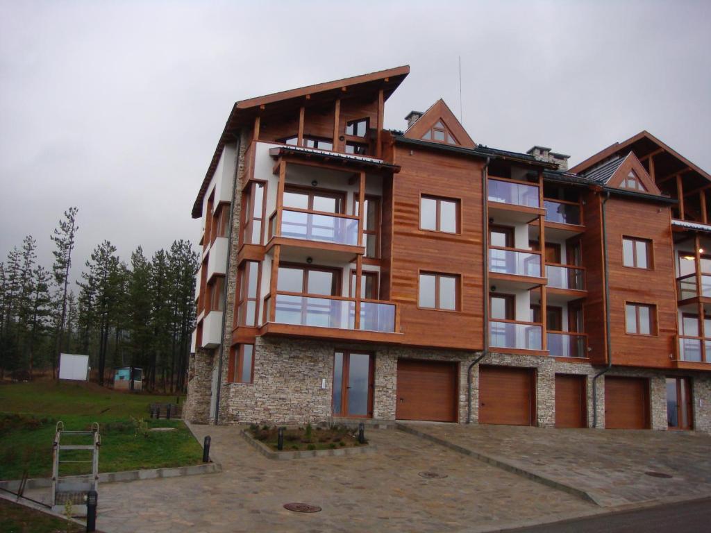 a large wooden building with a lot of windows at Entire Private Apartment in Pirin Golf & Country Club in Bansko
