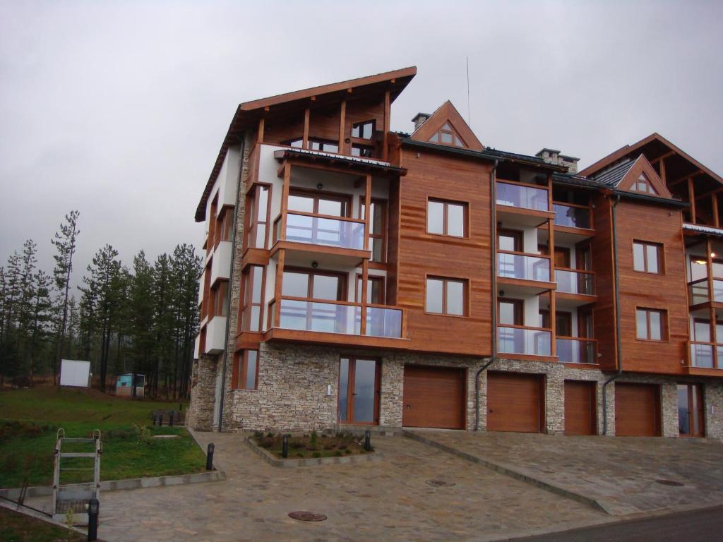 a large wooden building with a lot of windows at Entire Private Apartment in Pirin Golf & Country Club in Bansko