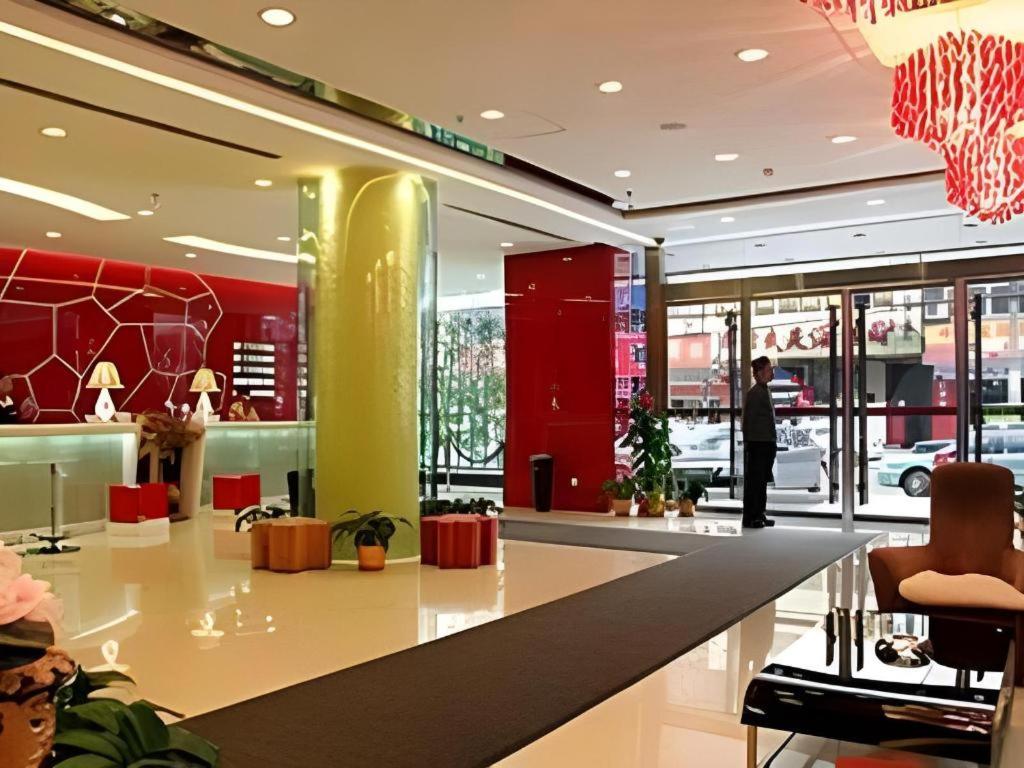 eine Lobby eines Ladens mit einer Person im Hintergrund in der Unterkunft Tomolo Hotel Wuzhan Branch in Wuhan