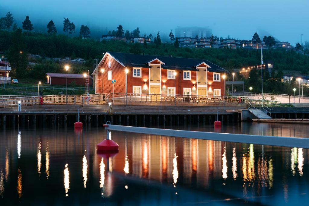 une maison sur un quai dans l'eau la nuit dans l'établissement Örnsköldsviks Gästhamn, à Örnsköldsvik