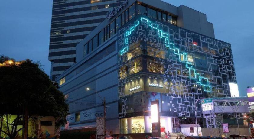 ein hohes Gebäude mit Lichtern an der Seite in der Unterkunft Silom Studios in Bangkok