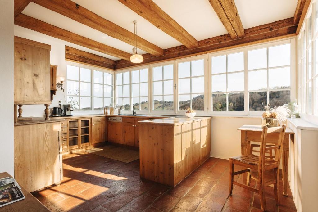 FötschachDas KRANACH 28的厨房设有木制橱柜和大窗户。