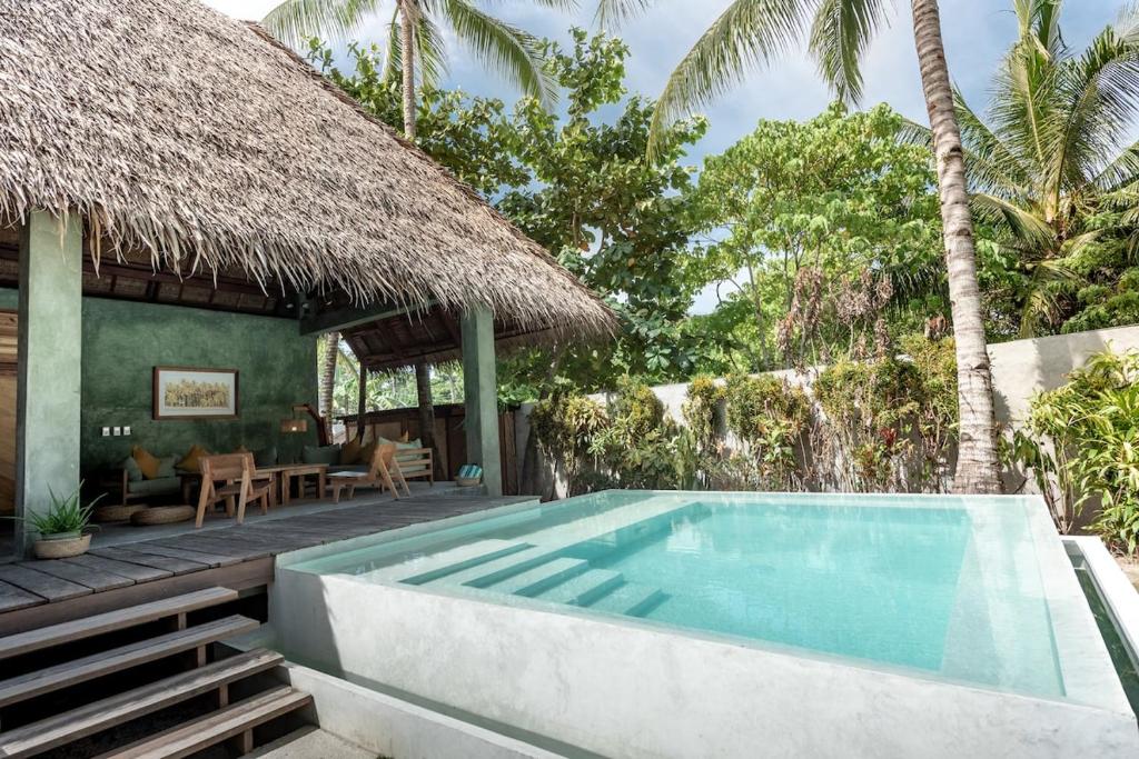 a swimming pool next to a villa with a resort at Tadhana Villa in General Luna