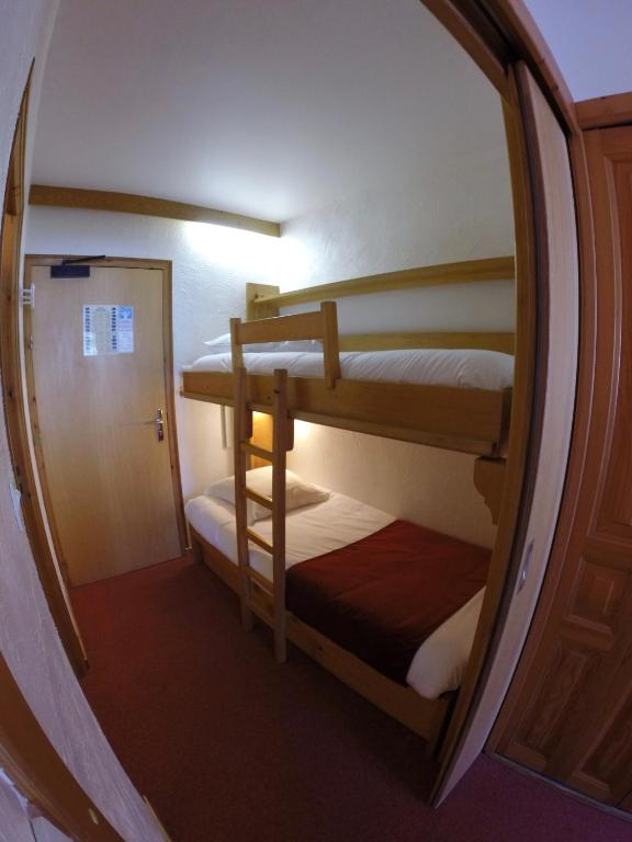 a small room with two bunk beds in it at Hôtel Les Côtes, Résidence Loisirs et Chalets in Morzine
