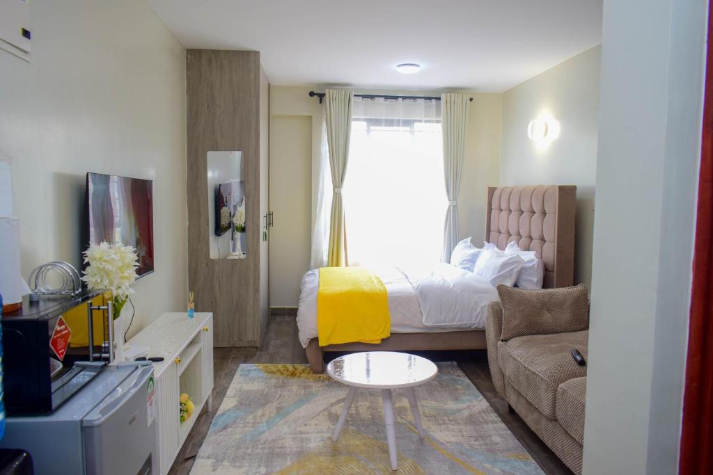 a small room with a bed and a couch at Stayride Homes in Ruaka