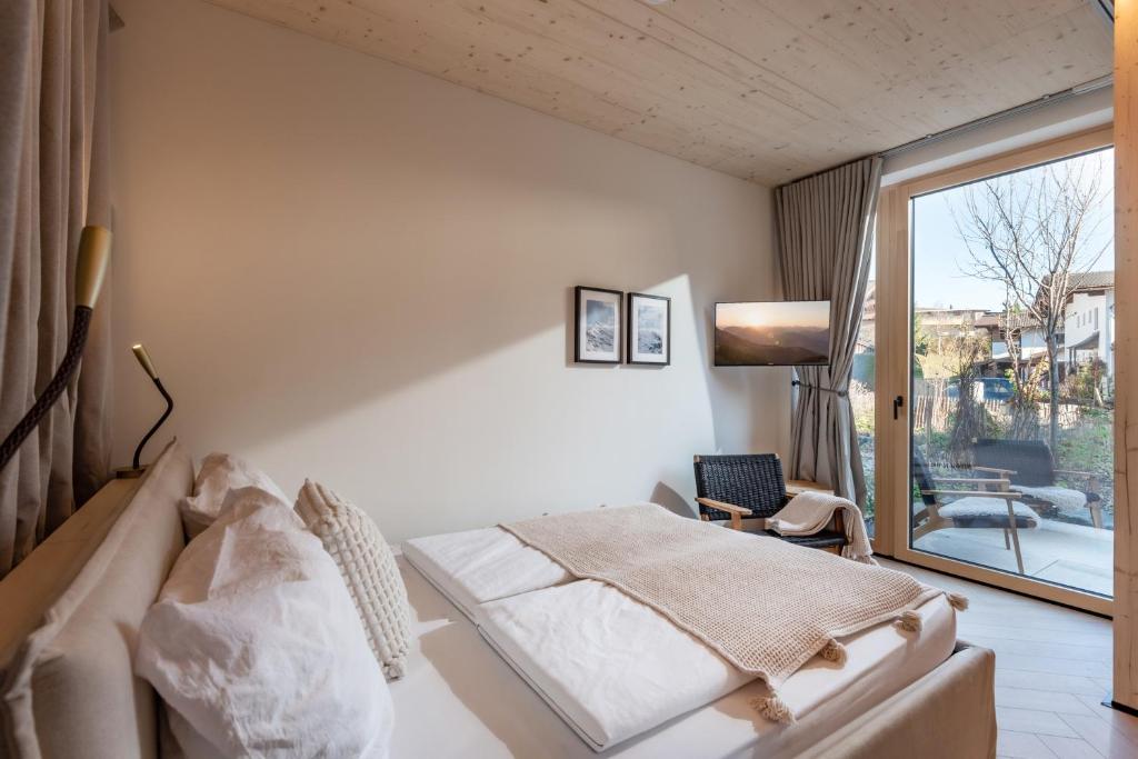 Un dormitorio con una cama y una ventana grande en Langerwegh Apartments AP1, en Fieberbrunn