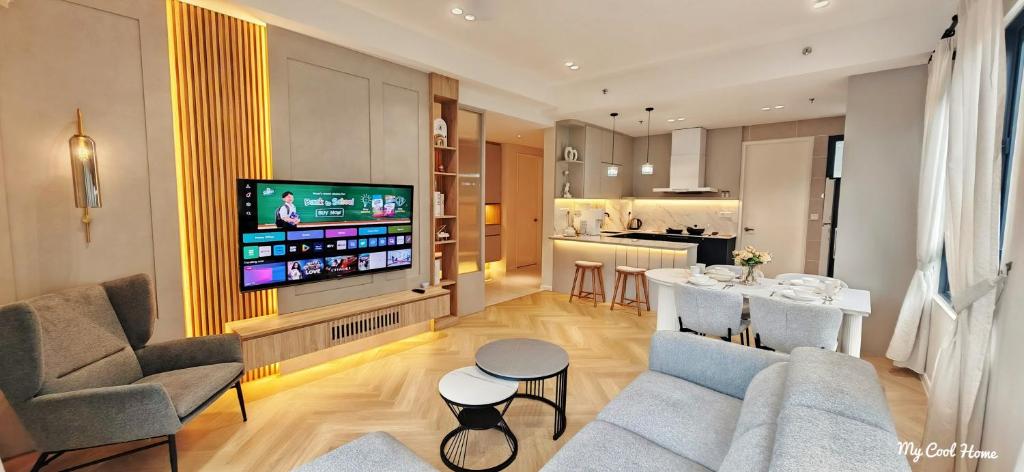 a living room with a couch and a tv and a kitchen at Onsen Suite Theme Park View in Ipoh