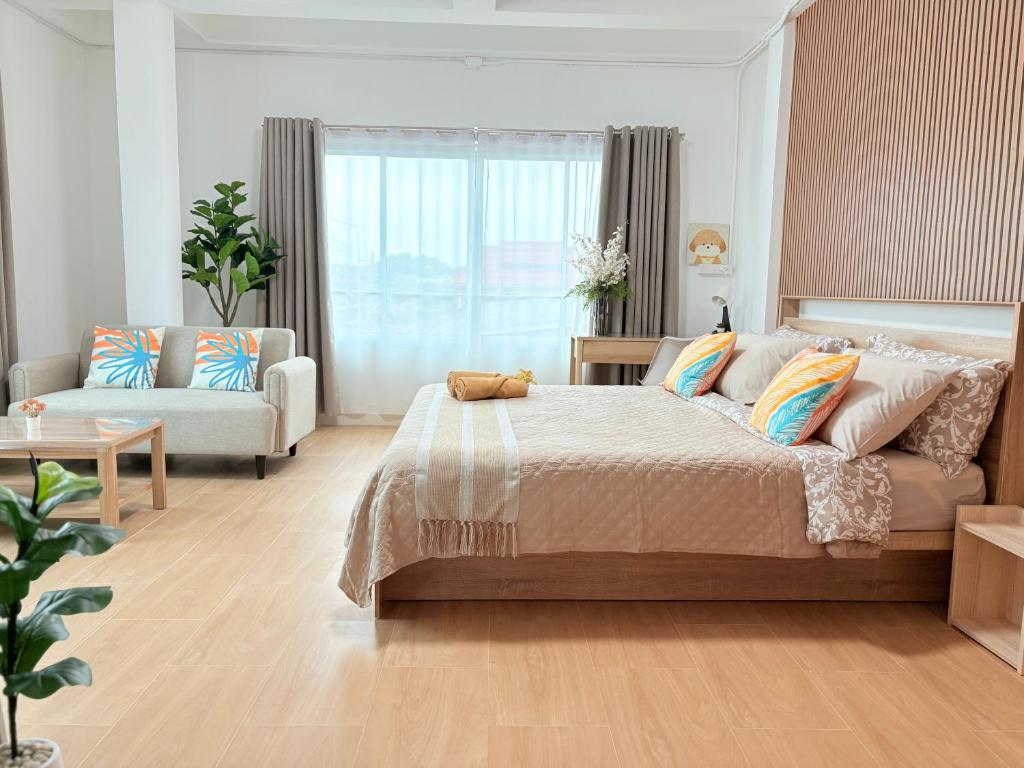 une chambre avec un grand lit et un canapé dans l'établissement Na KlongMuang I ณ คลองเมือง, à Phra Nakhon Si Ayutthaya