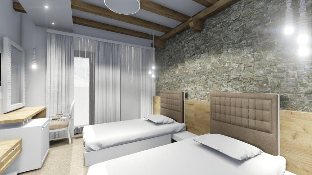 a bedroom with two beds and a stone wall at Kuća za odmor Vila in Vrsar