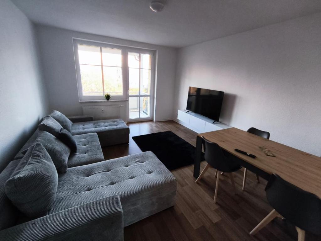 a living room with a couch and a table at Business Apartment Chemnitz in Chemnitz