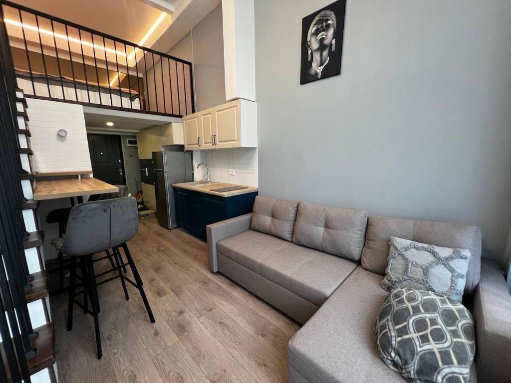 敖德萨Апартаменти Аркадія, з терасою та 3 хв до моря的客厅里有一张沙发和一个厨房