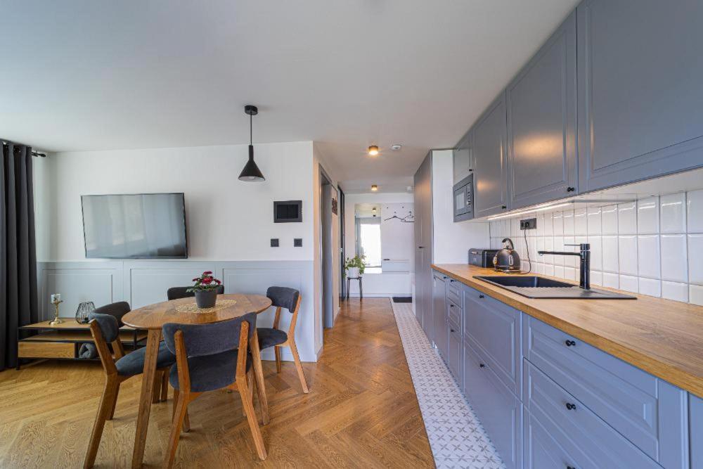 une cuisine avec une table et une cuisine avec des armoires bleues dans l'établissement Apartmán Pradědův, à Šumperk