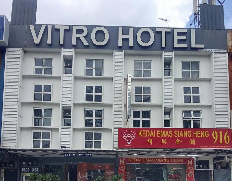 a white hotel with a sign on the front of it at Vitro Hotel in Johor Bahru